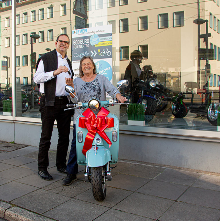 Gewinnerin Lieselotte Lämmle und Ralf Maier-Geißer (Stadt Stuttgart) bei der Schlüsselübergabe für den Retro-Elektro-Roller