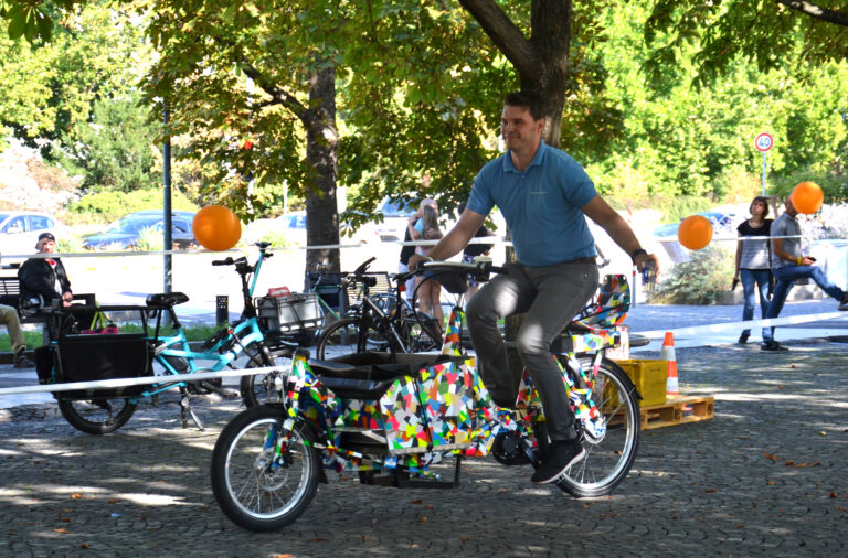 Ein Mann fährt auf einem Lastenrad durch einen Hindernisparcours